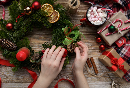 Christmas home decoration, female hands holding a wreath, hand made. High quality photoの写真素材