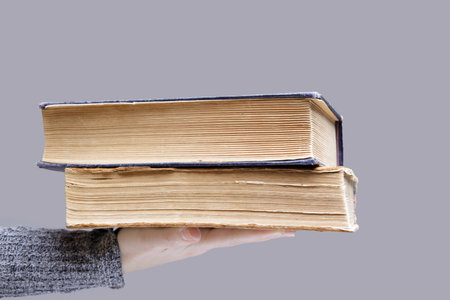 stack of old books in the palm of an invisible person. High quality photoの写真素材
