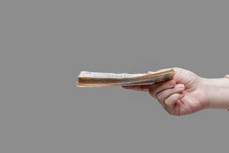 Hand holds a stack of five hundred hryvnia bills, side view. High quality photoの写真素材