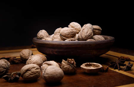 Nuts. Walnut kernels and whole walnuts on a dark wooden table. dark background. selective soft...