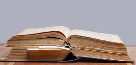 two old open books with bookmarks lie on a wooden table, close-up. High quality photoの写真素材