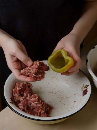 woman hands fills the bell peppers with minced meat. step by step preparation . dinner . selective soft focus . process cooking .の写真素材