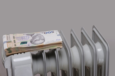 stack of large paper banknotes on an electric heating radiator. selective focus.High quality photoの写真素材