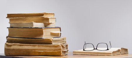 stack of old books and reading glasses lie on the table. selective focus .High quality photoの写真素材