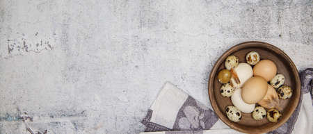 fresh quail and chicken eggs from the farm in a brown clay plate on a gray marble table. selective soft focus. top view .High quality photoの写真素材