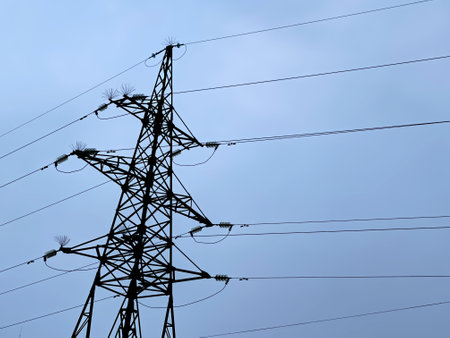 iron pillar with high-voltage wires against the blue sky. evening. High quality photo