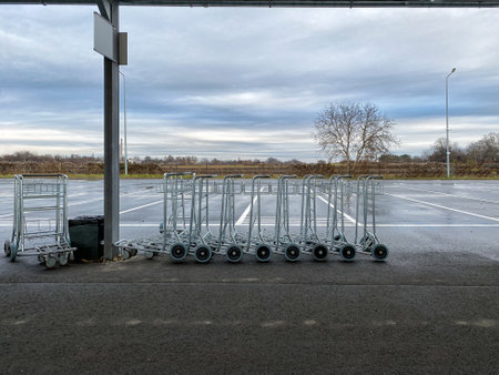 empty luggage trolleys standing on the bus station on a gloomy autumn day. selective focus.High quality photoの写真素材