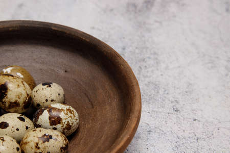 fresh quail eggs from the farm in a plate of brown clay on a gray marble table. selective soft focus. High quality photoの写真素材