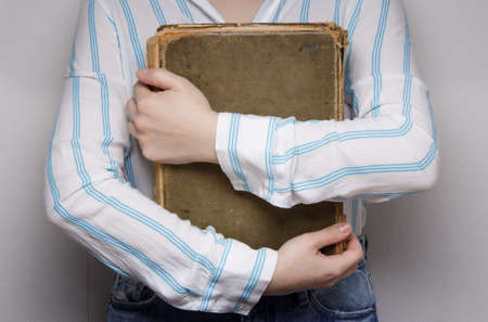 hands of an invisible person holds hugs an old book. . High quality photoの写真素材