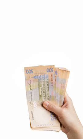 hand holds a bundle of five hundred hryvnia banknotes on a white background. isolate. selective focus. free space for text. High quality photoの写真素材
