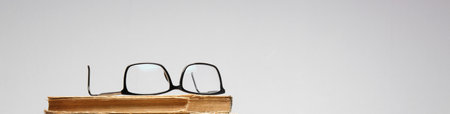 glasses lie on top of an old book. close-up. selective focus. High quality photo