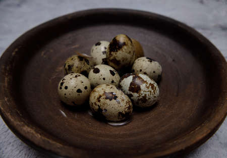 fresh quail eggs from the farm in a brown clay plate.selective soft focus