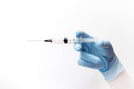 hand of a nurse in nitrile blue gloves holds a syringe with a medicine. selective focus. isolated on white backgroundの写真素材