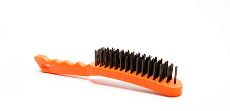 Wire brush, a tool consisting of a brush whose bristles are made of steel wire. Metal brush with plastic orange handle. A tool for removing rust or paint. isolated on white backgroundの写真素材