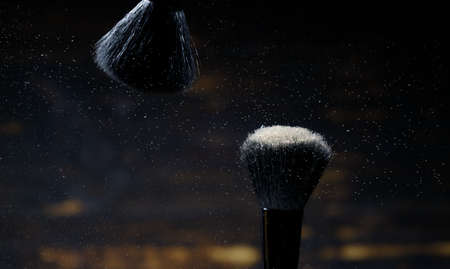Makeup brushes with flying around powder. on a dark background