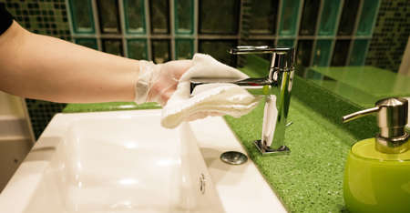 hand of invisible worker glove of nitrile washes the faucet over the washstand. selective focus.High quality photoの写真素材