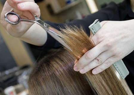 hairdressers hands with scissors and a comb haircut client. selective focus.High quality photoの写真素材