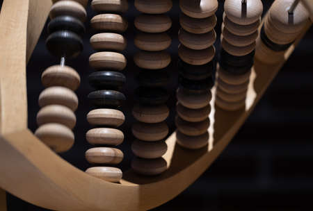 wooden curved abacus on a black background. Close-up. High quality photoの写真素材