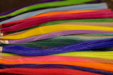 strands of natural dyed hair of bright colors in the palette on the table. selective focusの写真素材
