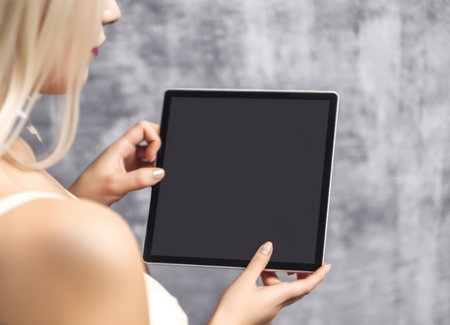 Mockup image of female hands holding and using black tablet pc with blank black desktop screen. Generative AIの素材