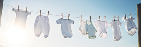 washed clothes hanging on a clothesline in the street on a sunny day. Washday. Generative AIの素材