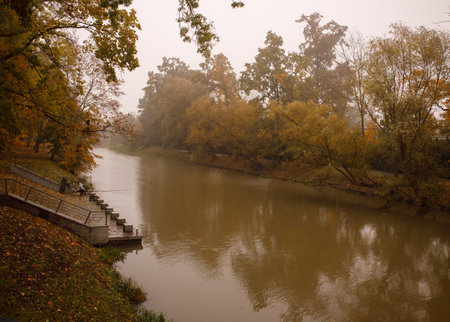 lone fisherman who catches fish on a foggy autumn morning on the river. selective focusの写真素材