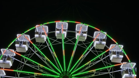 A brightly illuminated Ferris wheel against the night sky.の写真素材