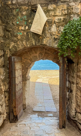 an ancient stone arch with a path to the sea. High quality photosの写真素材