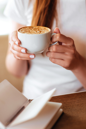 Beautiful girl in cafe with tasty capuccino.の写真素材