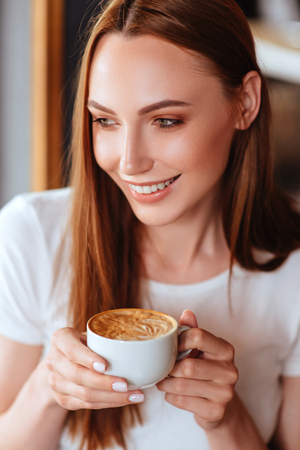 Beautiful girl in cafe with tasty capuccino.の写真素材