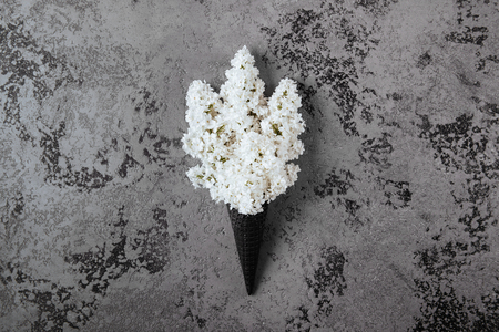 Waffle cone with lilac flower bouquet on gray background.の写真素材