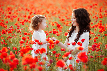 mother and daughter playing in flower fieldの写真素材