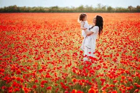 mother and daughter playing in flower fieldの写真素材