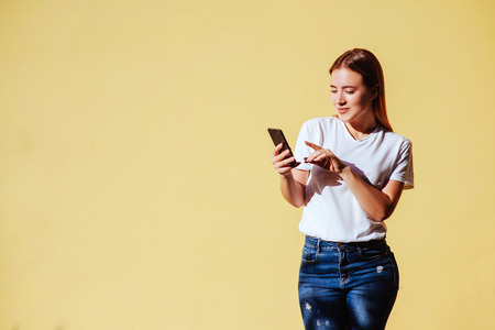 Portrait of smiling beautiful girl against of yellow background.の写真素材