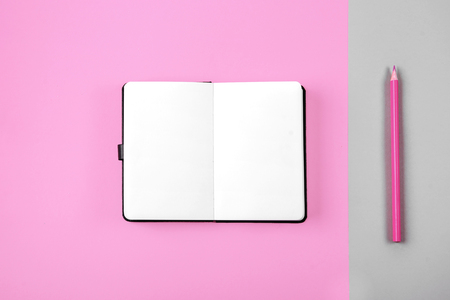 Macaron, clean notebook, eyeglasses on pink table from above. Female working desk. Flat lay style.の写真素材