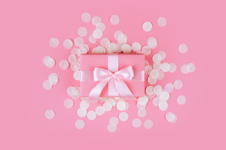 Present box with pink bow on pastel pink background.の写真素材