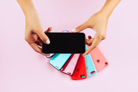 Woman Hand holding smartphone on pink backgroundの写真素材