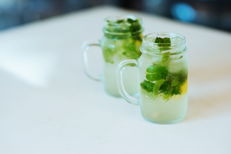 Lemonade from lime with mint, mohito, with ice, glass jar, mason jar, in city cafe.の写真素材