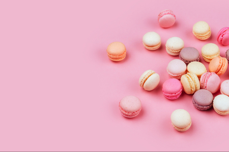 Different types of macaroons on pink background.の写真素材