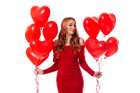 Attractive young girl in red dress holding Valentines Day helium balloonの写真素材