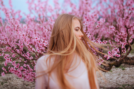 portrait of young lovely woman in spring flowersの写真素材