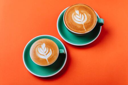Cyan coffee cups over orange background.の写真素材