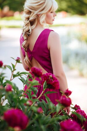 Outdoor close up portrait of beautiful young woman in the blooming garden. Female spring fashion conceptの写真素材