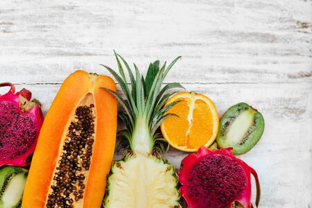 Tropical fruits lie on a wooden white surface.の写真素材