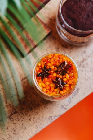 Sea buckthorn tea with orange in a glass cups with fresh sea buckthorn berries and leaves. Herbal vitamin tea.の写真素材