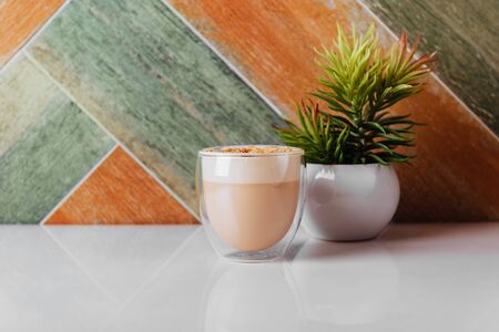 glass of latte coffee on light tableの写真素材