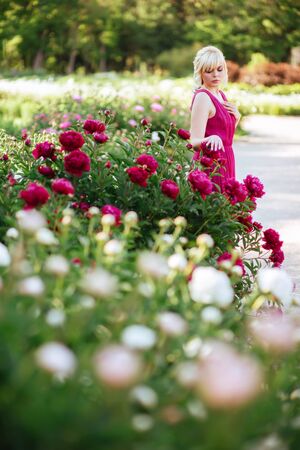 Outdoor close up portrait of beautiful young woman in the blooming garden. Female spring fashion conceptの写真素材