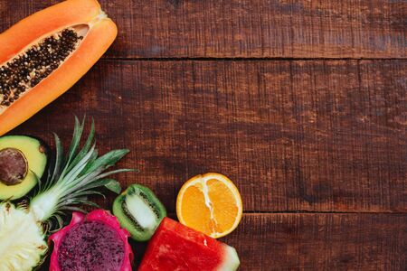 Tropical fruit on dark wooden background