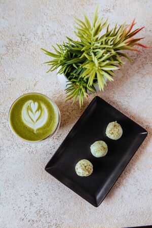 hot mocha green tea latte with candies on light texture backgroundの写真素材
