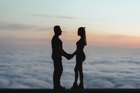 Happy couple watching one another under the sunset sky